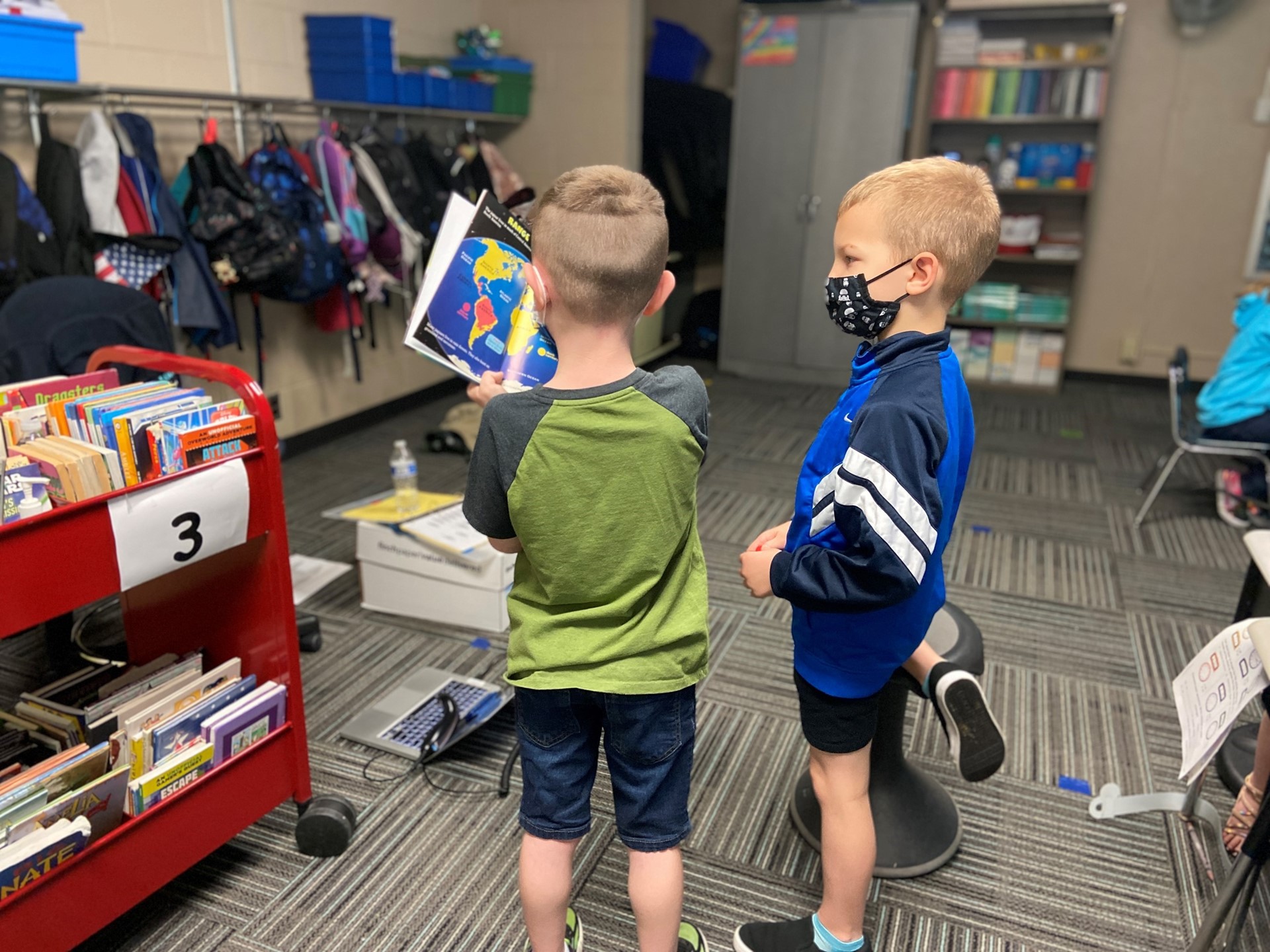 Students examine a map in a book.