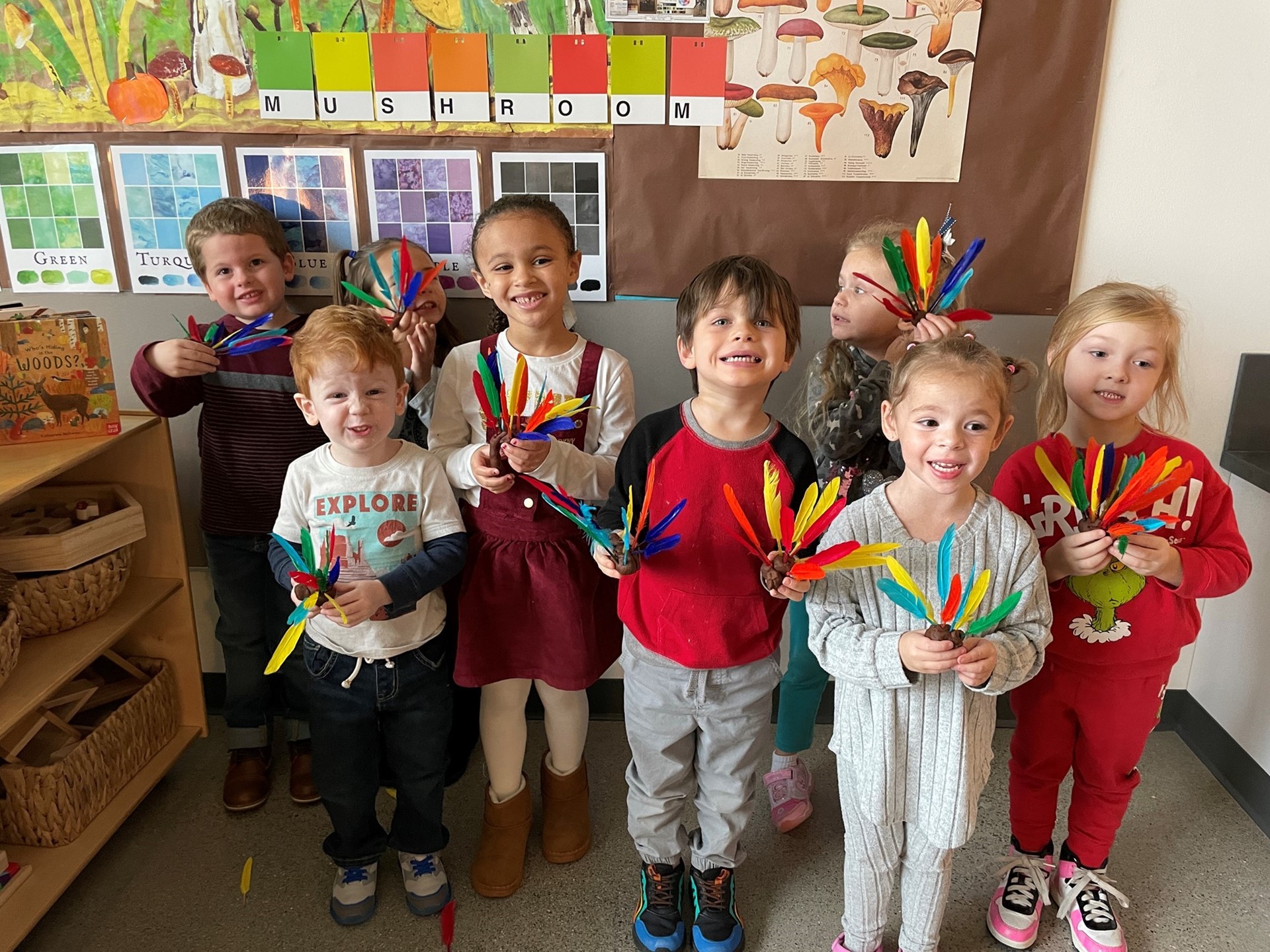 Elementary art students posing with colorful turkeys. 