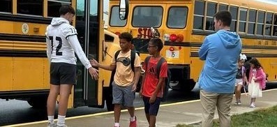 Football players greeting elementary students. 